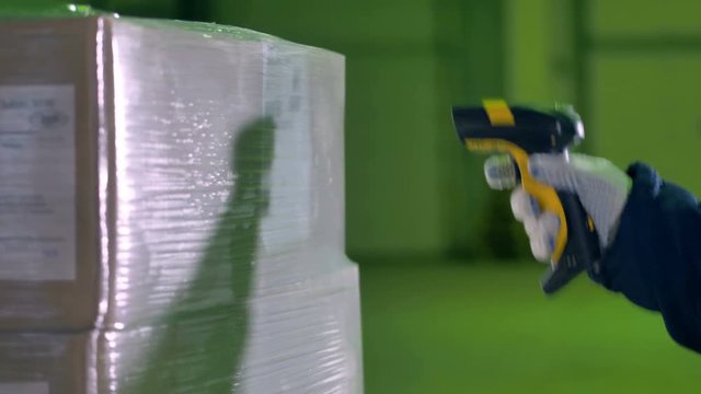 Workers hand with Bar Code Scanner scanning goods at a warehouse. 4K.