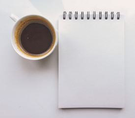 A notebook and a Cup of coffee on a white background. Top view