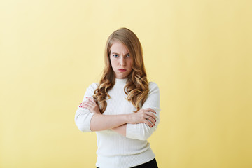 Portrait of displeased furious young woman frowning, keeping arms crossed, expressing dislike and disapproval about some idea. Angry mother forbidding her son to go out because of misbehaviour