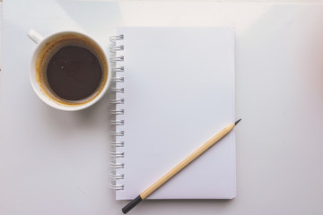 A notebook, a pencil, a Cup of coffee on a white background. Top view 