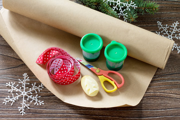 Child draws details of Christmas gifts box and snowman sweets. Made by own hands. Children's art project for children. Craft for kids.