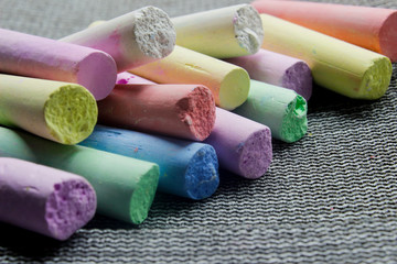 multi-colored chalk on a gray background close-up.