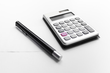 calculator with a pen and paper note with debt word isolated on white background