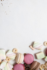 Top view colorful sweets with free space on white background. Delicious macaroons, zephyrs and breakfast cereal close up