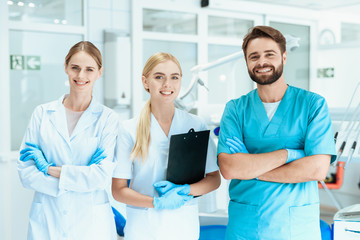 Obraz premium A dentist and two nurses are posing in a dental office. They are smiling