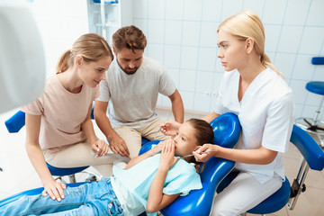 Obraz premium A man and a woman led the girl to see a dentist. The girl is afraid