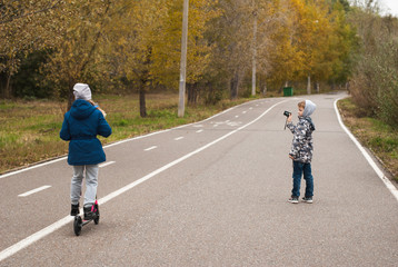 Fototapeta premium children in autumn Park, girl rides a scooter in the fall,