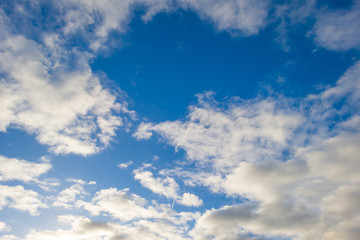 Clouds in a blue sky in sunlight at fall