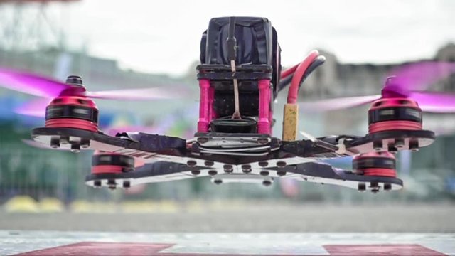 FPV racing drone is taking off the ground in slow motion. Closeup detailed slowmo shot.