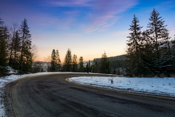 red dawn on serpentine in winter forest. beautiful nature scenery in mountains. lovely transportation background