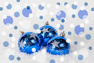 Blue Christmas baubles on white snow with blue sparkling background. Finland 100 Festive winter and flag color concept.6.12.2017