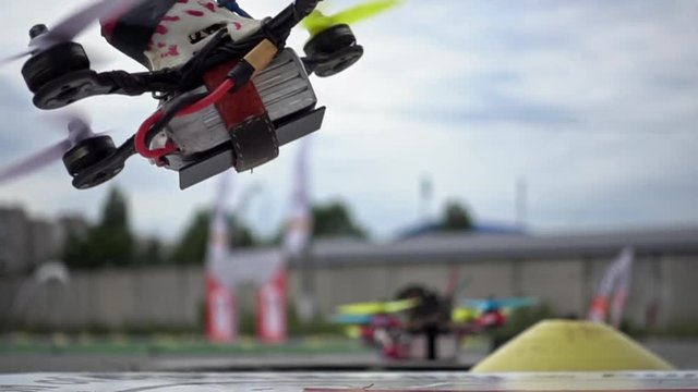 FPV racing drone is taking off the ground in slow motion. Closeup detailed slowmo shot.