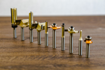 Mills exposed in a row on a wooden dark background. Milling cutter and router bit. Carbide drill or milling cutter. © Вячеслав Козырев