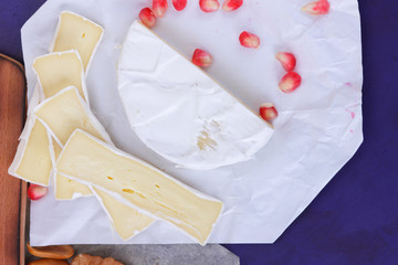 Camembert cheese, marbled cheese, different cheeses, dark blue grapes, red pomegranate, green...