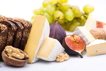 cheese with a mix of snacks, grapes, nuts and figs isolated