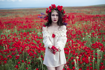 The girl poses on a poppy field