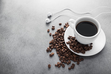 White cup of coffee with headphone and coffee beans