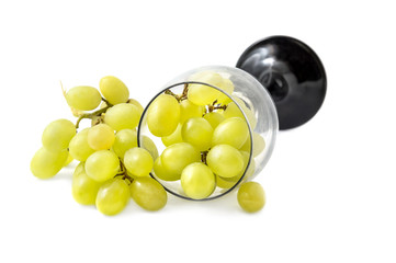 Green grapes with wine glass on white background.