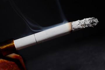 Smoking white cigarette on black background