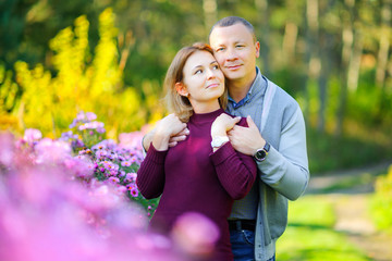 Obraz premium a pair of lovers strolls in the evening park, gently hug and smile