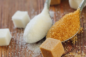 White and brown sugar in spoon