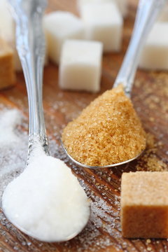 White and brown sugar in spoon