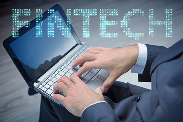 Hands working on laptop in financial technology fintech concept