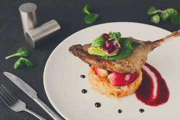 Restaurant meals. Duck confit with vegetables on black backgroun