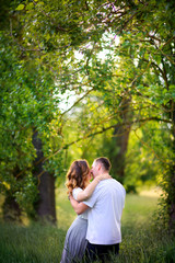 Fototapeta premium two lovers walk in a field with a tall Tava, hug and kiss