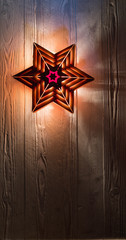 Naklejka premium Wooden star lights on old wooden rustic background. Christmas, holiday, halloween concept. Copy space