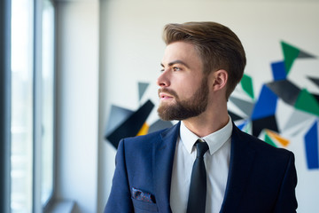 Businessman looking through window in office