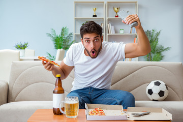 Man eating pizza having a takeaway at home relaxing resting