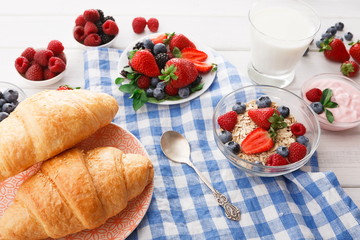 Continental breakfast with croissants and berries on checkered cloth
