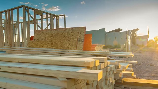 From Sunset to New Home Construction Build Site. view moves from the sun setting in a neighborhood and pans left to reveal a construction site for a new residential home build
