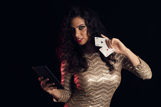 Attractive, sexy young woman holding to aces and tablet in hands, online poker 