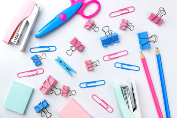 Stationary concept, Flat Lay top view Photo of Scissors, pencils, paper clips, post it,stapler in pink and blue tone on white background with copy space