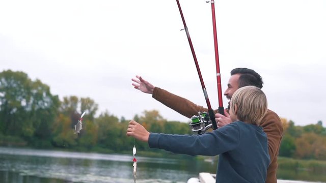 Dad and his son caught a fish.