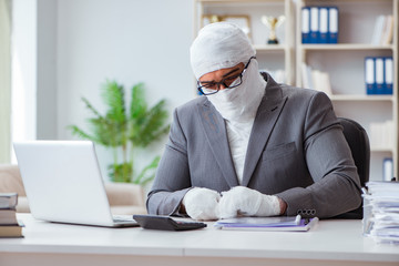 Bandaged businessman worker working in the office doing paperwor