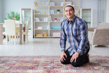 Fototapeta premium Young muslim man praying at home