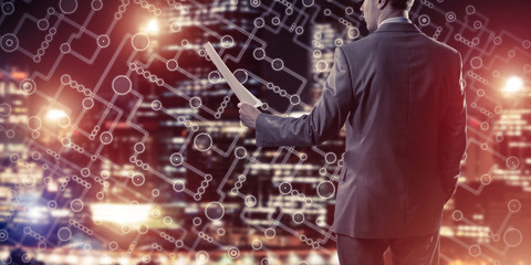 Rear view of businessman against night cityscape background and 