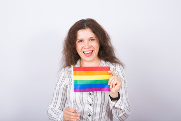Young lesbian woman holding flags of the LGBT community on a white background