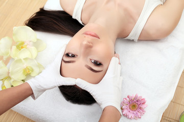 Obraz na płótnie Canvas Spa relaxation, skincare, healthy pleasure concept. Woman lying with closed eyes having relaxing face massage