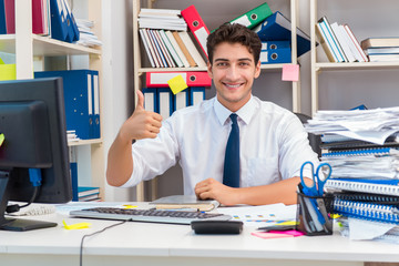 Businessman working in the office with piles of books and papers