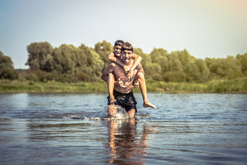 Playful children having fun on river during summer holidays in countryside symbolizing carefree childhood  