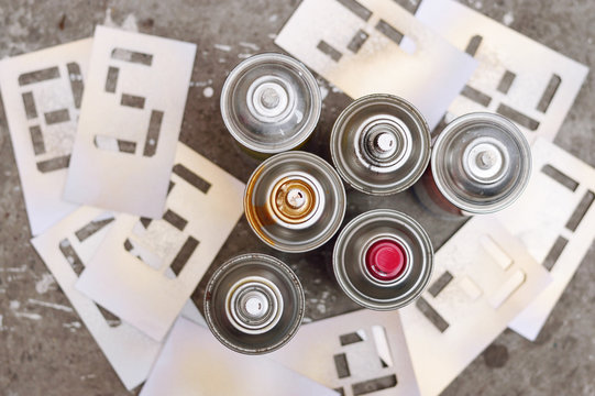 six spray cans with stencil numbers
