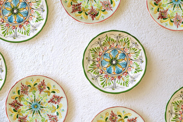 Some colored ceramic plates on a wall of a Patio in a Spanish city. Mediterranean background. Empty copy space for Editor's text.