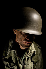Fototapeta premium Portrait of combat stressed US Marine (Vietnam War) with face covered in mud.