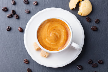 Coffee espresso in white cup on black slate background. Top view.