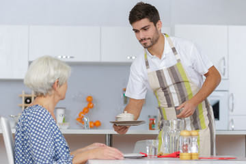 elder woman enjoying tea with his caretaker