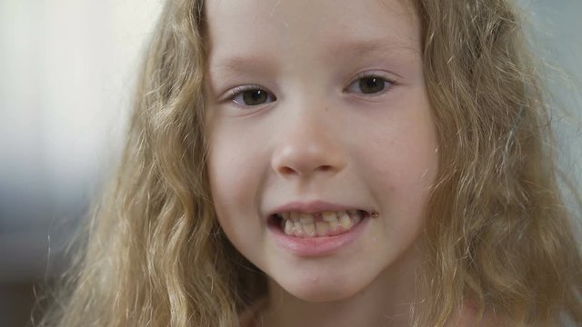 Funny blond child showing teeth into camera, children's orthodontics, health
